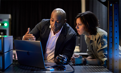 Mike e um colega num laboratório a olhar para um MacBook.