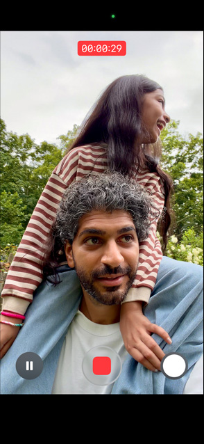 iPhone 17 ekraan, mis näitab stabiliseeritud videot, kus mees kannab väikest tüdrukut oma õlgadel