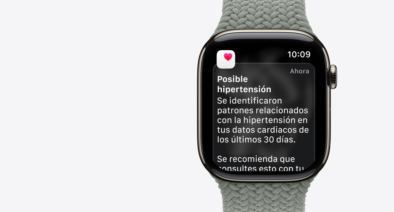 Apple Watch Series 11, color natural, caja de titanio, notificación de posible hipertensión, corazón rosa en un recuadro blanco, parte lateral derecha, Digital Crown, correa uniloop trenzada gris verdoso