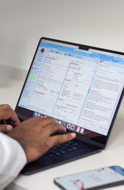 Một nhân viên y tế đang kiểm tra Hồ Sơ Sức Khỏe Điện Tử trên MacBook Pro.