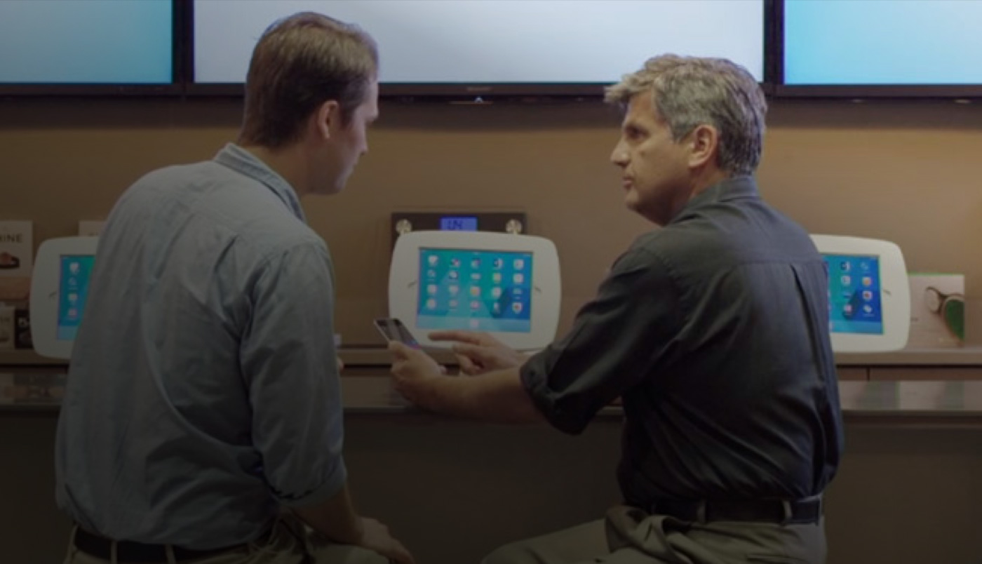 رجلان يجلسان أمام O&nbsp;Bar وينظران إلى شاشة iPhone.