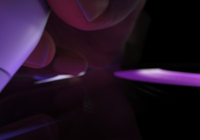 Una mano che tiene una Apple Pencil Pro e preme la punta sul display, tracciando una grossa linea di colore viola brillante.