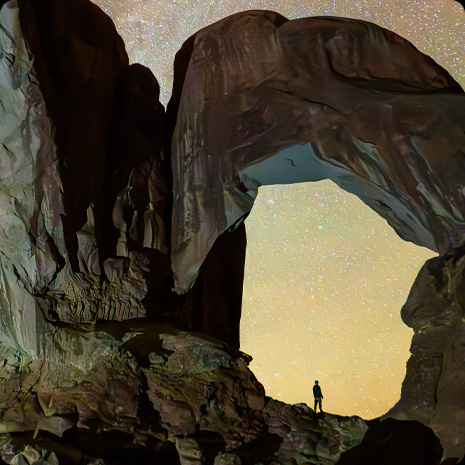 iPad Pro display showing a photograph of a person in a canyon and a star-filled night sky