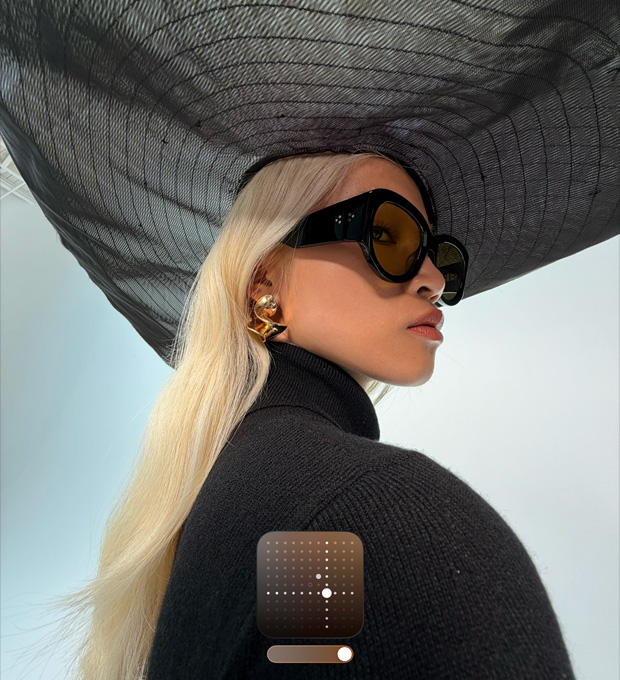 Das Porträt einer Frau mit einem breitkrempigen schwarzen Hut zeigt den Fotografischen Stil Hell, der bei wenig Licht oder im Nachtmodus aufgenommene Fotos aufhellt