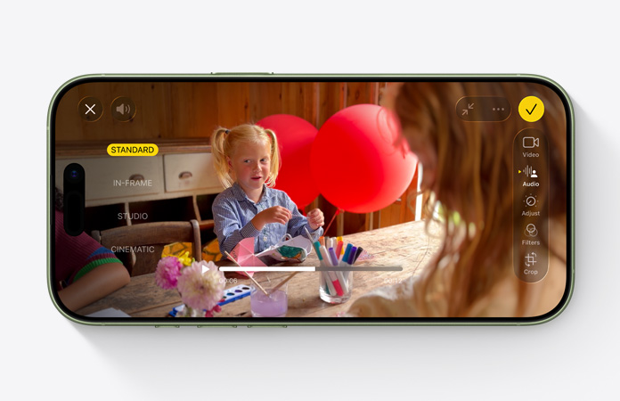 iPhone 17, voorkant, video van een kind dat speelt aan een tafel met ballonnen waarbij de feature Audiomix wordt gebruikt
