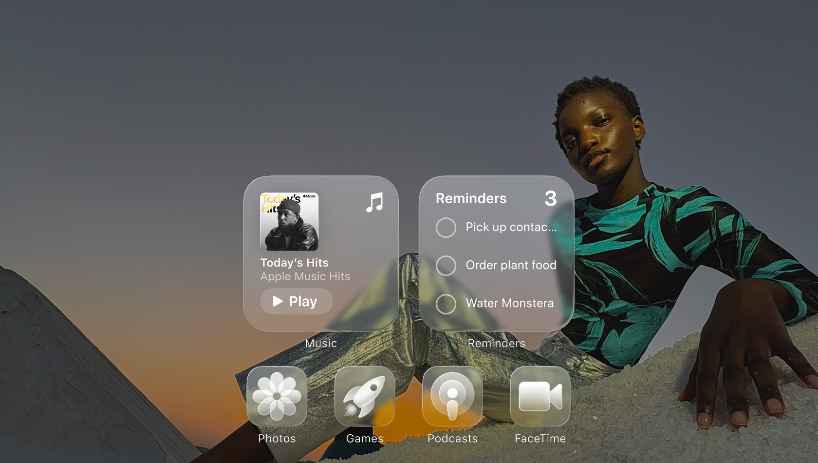 Ecrã Liquid Glass com ícones de apps transparentes, como Apple Music, Lembretes, Fotografias, Jogos, Podcasts e FaceTime, e um efeito de refração no papel de parede