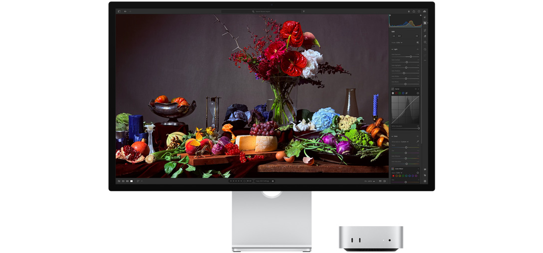 Висококонтрастне зображення столу з різними тарілками з їжею та букетом квітів на темному тлі, що демонструє, як технологія True Tone регулює колірну температуру.