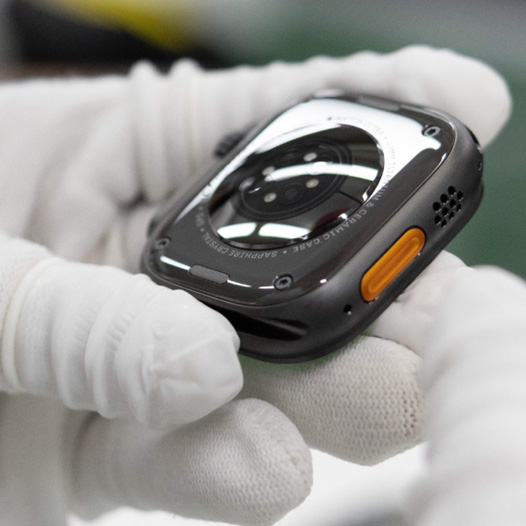 Gloved hands hold the base of an Apple Watch backside up