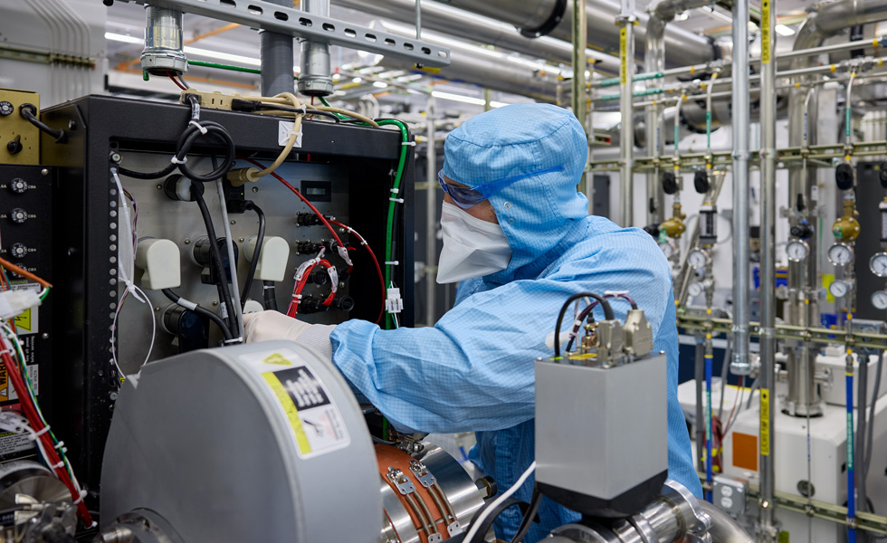 Dipendente con una tuta protettiva che ispeziona un macchinario