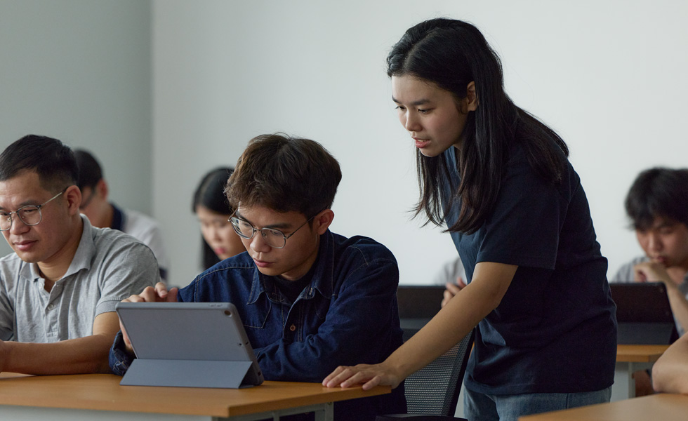 Due persone in un’aula che collaborano su un tablet Apple