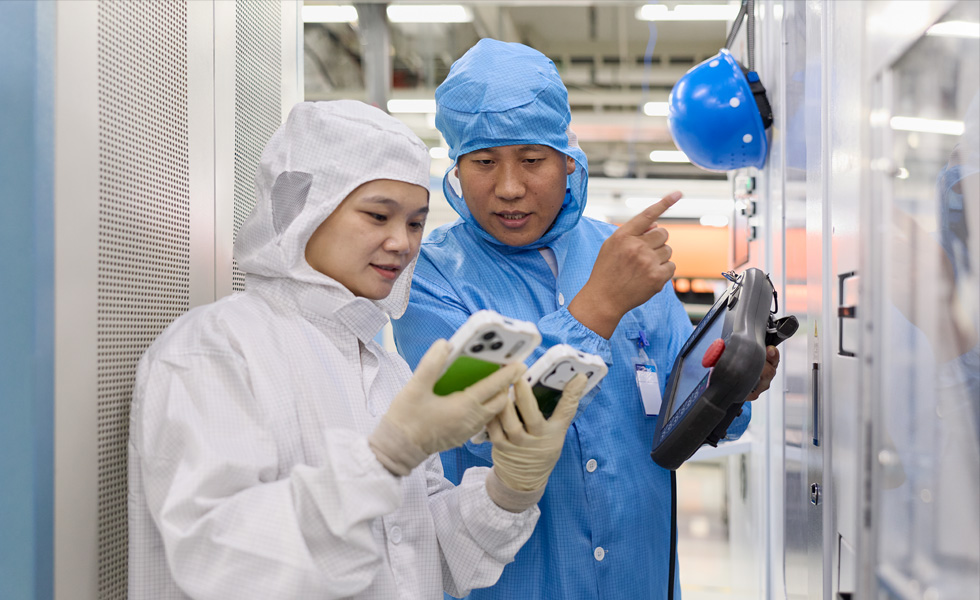 Due persone in tuta protettiva collaborano usando due iPhone